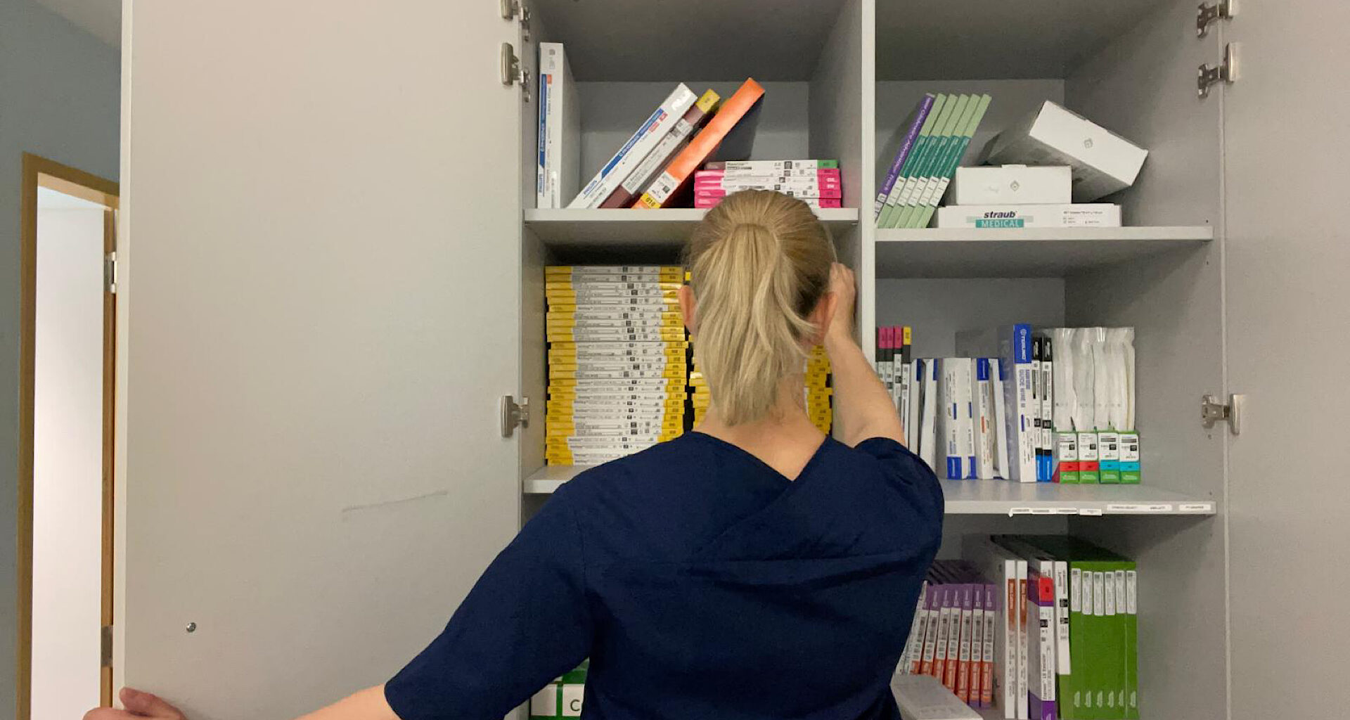 Titelbild: Pflegerin steht vor einem Medizinschrank, Foto von Celina Bozkurt