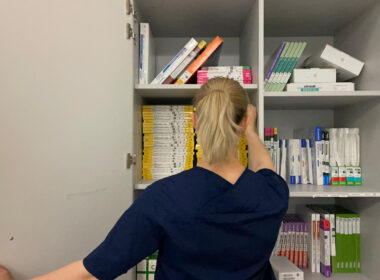 Titelbild: Pflegerin steht vor einem Medizinschrank, Foto von Celina Bozkurt